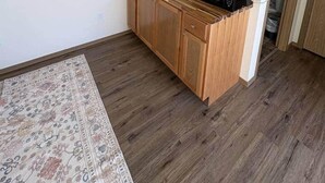 Cozinha compacta com armários de madeira, micro-ondas e pia.
