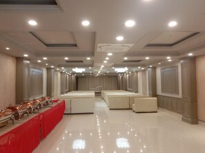 A spacious hotel room with a long dining table, multiple seating areas, and a modern ceiling design. - Hotel Hirapanna (Bareilly)