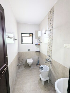 A compact bathroom with a toilet, bidet, and a small sink.