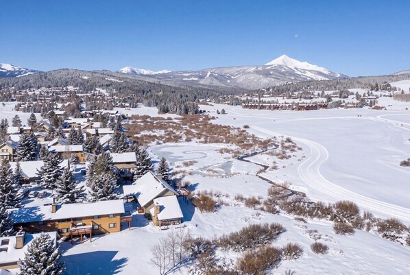 Un paysage enneigé avec un chalet et une piste de ski.