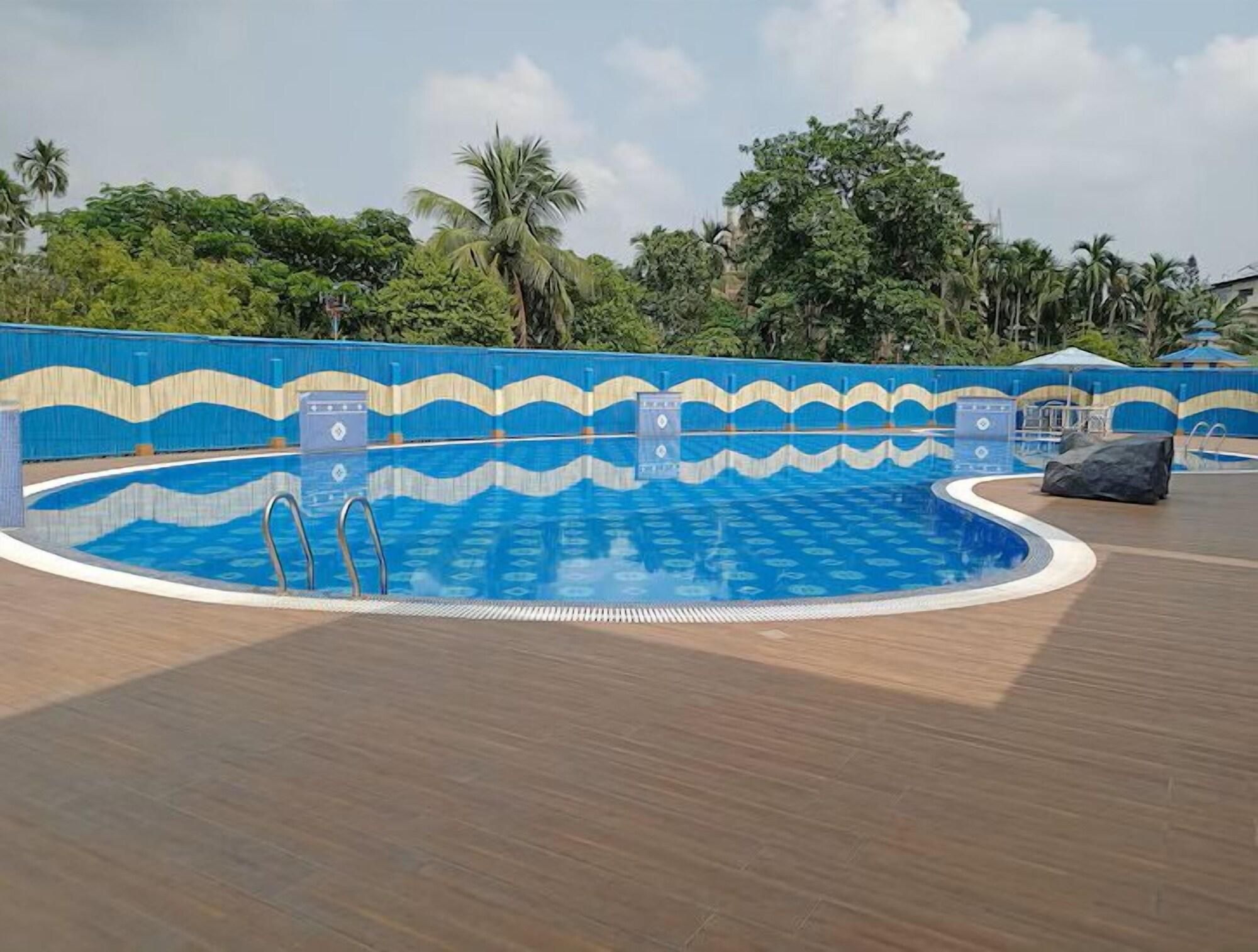 A swimming pool with a wavy blue and beige design on the walls, surrounded by a wooden deck.