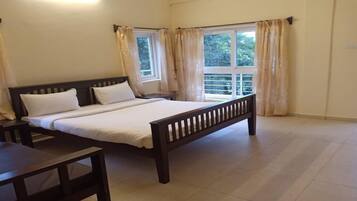 A bedroom with a bed, bedside tables, and curtains.
