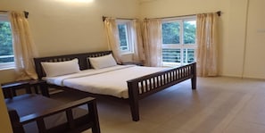 A bedroom with a bed, bedside tables, and curtains. - Temple Tree Residence (Tirupattur)