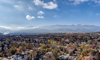 A residential area with houses, roads, and mountains in the background.
