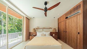 Un dormitorio con una cama grande, armario de madera, ventilador de techo y vistas a la vegetación.