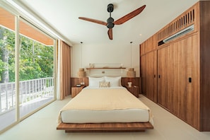 A bedroom with a large bed, wooden wardrobe, ceiling fan, and a view of greenery outside. - Villa Binginzie by Betterplace (Bingin)