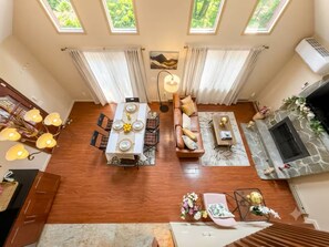 A spacious living area with a dining table, sofa, and fireplace. - Sauna Retreat 3-bedroom 3 bathroom Chalet House with AC (Tobyhanna)