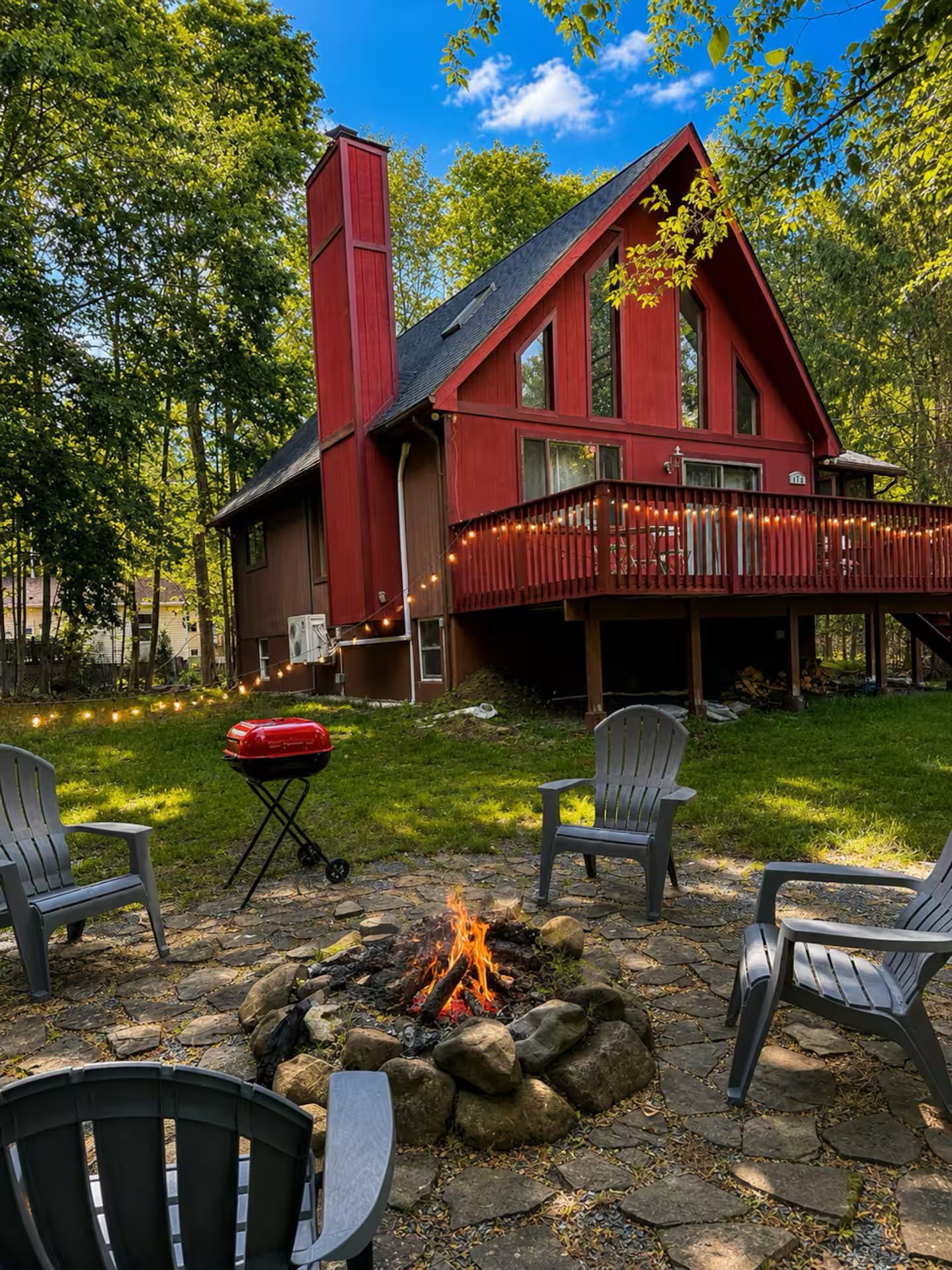 A red cabin with a fire pit and outdoor seating.