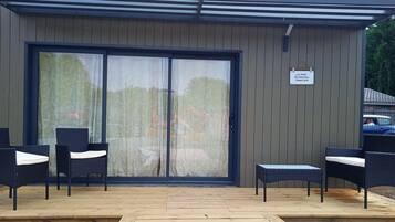Ein Außenbereich mit Korbmöbeln und einer Holzterrasse.