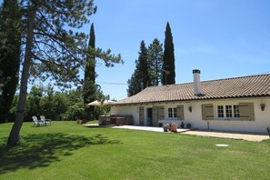 A two-story house with a tiled roof, a patio with outdoor furniture, and a well-maintained lawn. - Maison La Viste (Marseille)