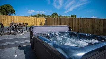 Un jacuzzi con una valla de madera al fondo.