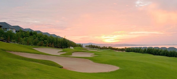 A golf course with bunkers and a sunset view. - Villa Panda At Sea Links Golf Resort (Phu Thuy)