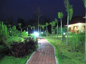 A pathway leading to a building with a well-maintained garden and palm trees. - Mai Siam Resort (Mae On)