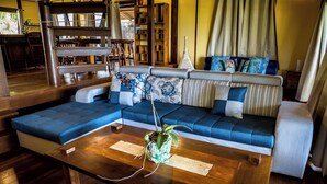 Una sala moderna con un sofá modular, una mesa de centro de madera y una estantería.