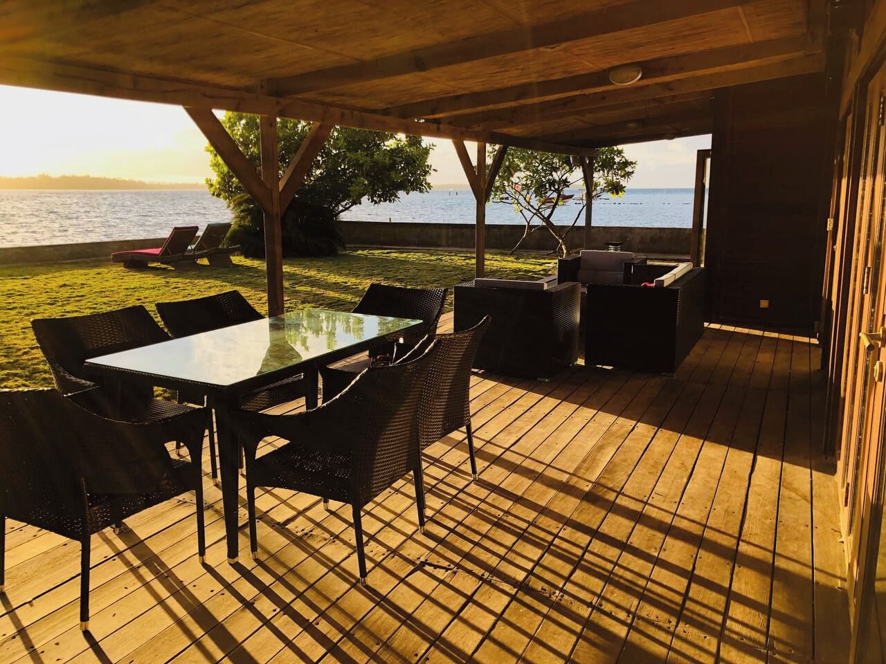 Une terrasse extérieure avec une table et des chaises, un barbecue et une vue sur la mer.