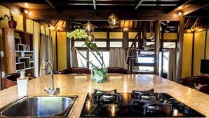 Una cocina con isla central, pileta de acero inoxidable y cocina a gas.