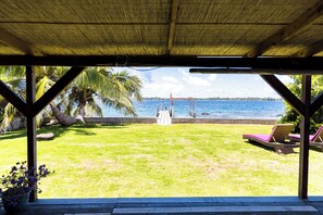 A covered outdoor area with a view of a beach and the sea. - Bora Bora waterfront sunrise villa (Bora Bora)