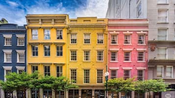 Une rangée d’immeubles à étages, chacun ayant une couleur distincte, une façade plate et une conception uniforme des fenêtres.