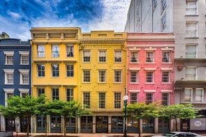 Une rangée d’immeubles à étages, chacun ayant une couleur distincte, une façade plate et une conception uniforme des fenêtres.