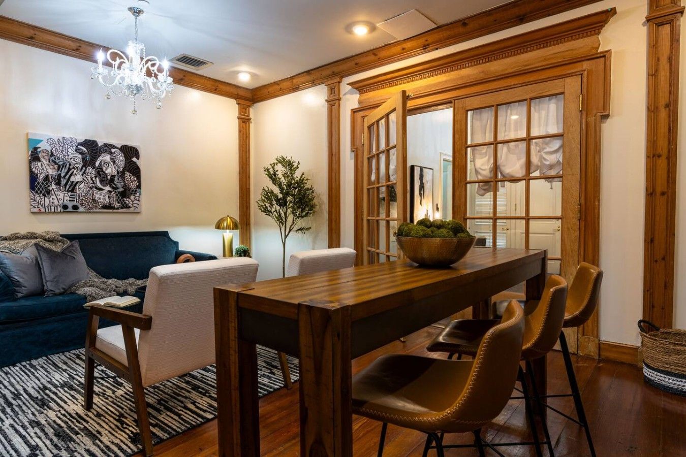 A dining area with a wooden table, leather chairs, and a chandelier.