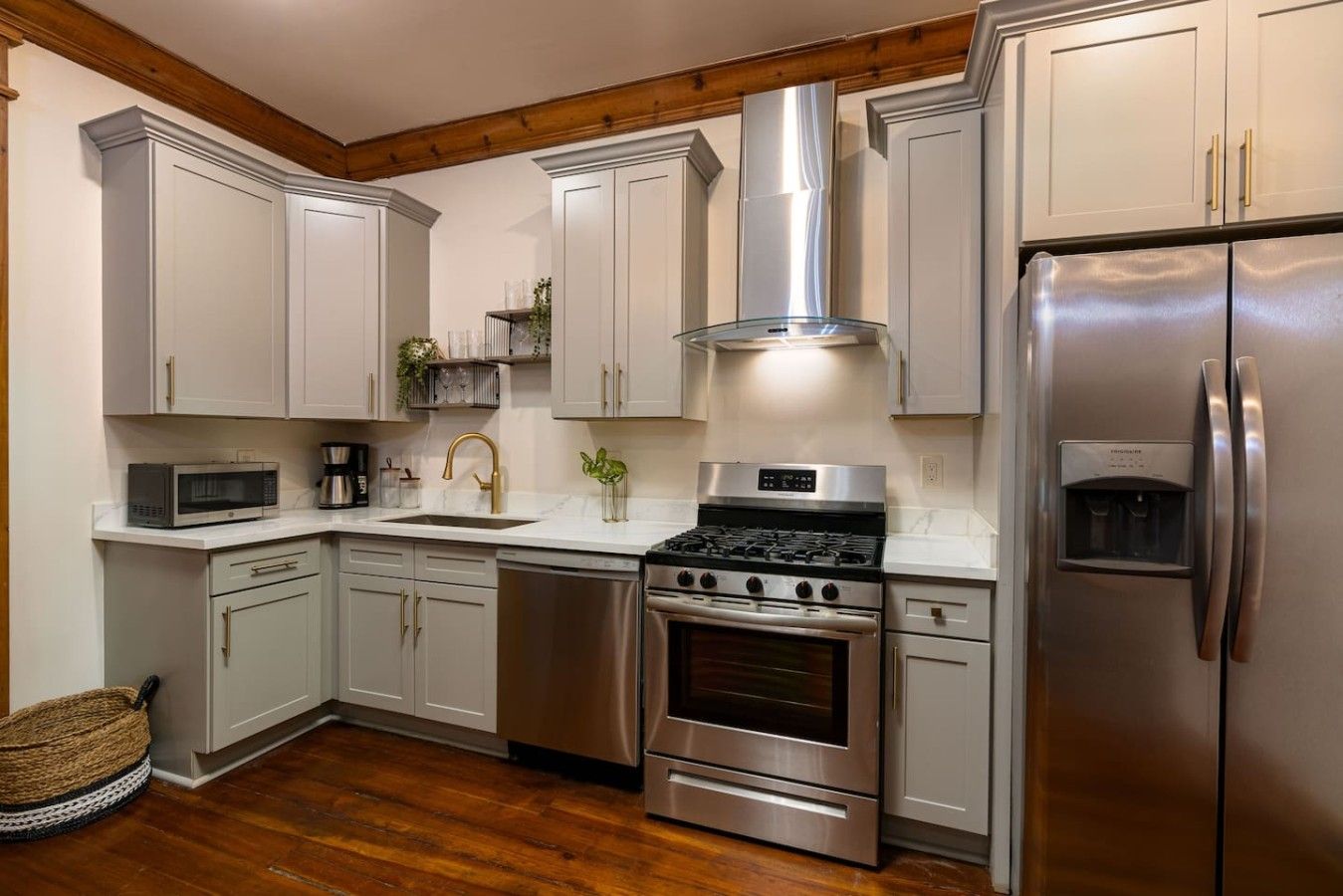 A kitchen with stainless steel appliances, white cabinetry, and a wooden ceiling.