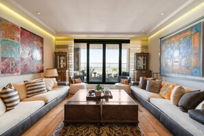 Ein geräumiges Wohnzimmer mit großem Couchtisch, Sofas und Kunstwerken an den Wänden.