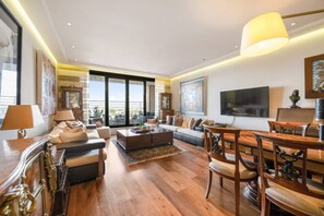 Ein geräumiges Wohnzimmer mit einer großen Couch, einem Couchtisch und einem Essbereich mit Stühlen.