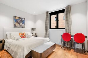 Ein modernes Schlafzimmer mit einem großen Bett, einem Schreibtisch und einem Stuhl.