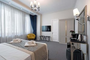 A hotel room with a bed, a television, a desk with a mirror, and a chair. - Highline Downtown Old Town Unirii Square (Bucharest)