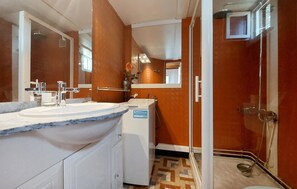 A bathroom with a sink, mirror, shower, and a towel rack. - Charmant studio au calme (Les Gours)