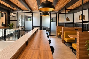 A modern interior with a long wooden table, yellow chairs, and black pendant lighting. - Stylish 2BR • Infinity Pool & Coworking  & GYM• Versalles (Puerto Vallarta)