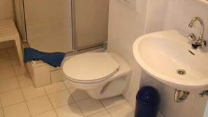 Ein Badezimmer mit Toilette, Waschbecken und Dusche.