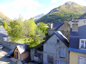 A residential area with stone buildings, a small carport, and a mountain in the background. - Hv¥tel Les Templiers (Luz-Saint-Sauveur)