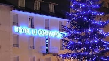 Een gebouw met een bord waarop 'HOTEL LE COMMERCES' staat.