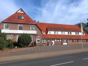 A two-story building with a red-tiled roof and a flat facade. - Hotel Wuelfers Gasthaus (Groß Ippener)
