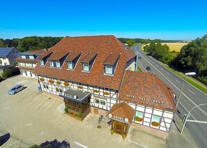 A hotel with a restaurant, multiple windows, and a parking lot. - Hotel & Restaurant Ernst (Giesen)