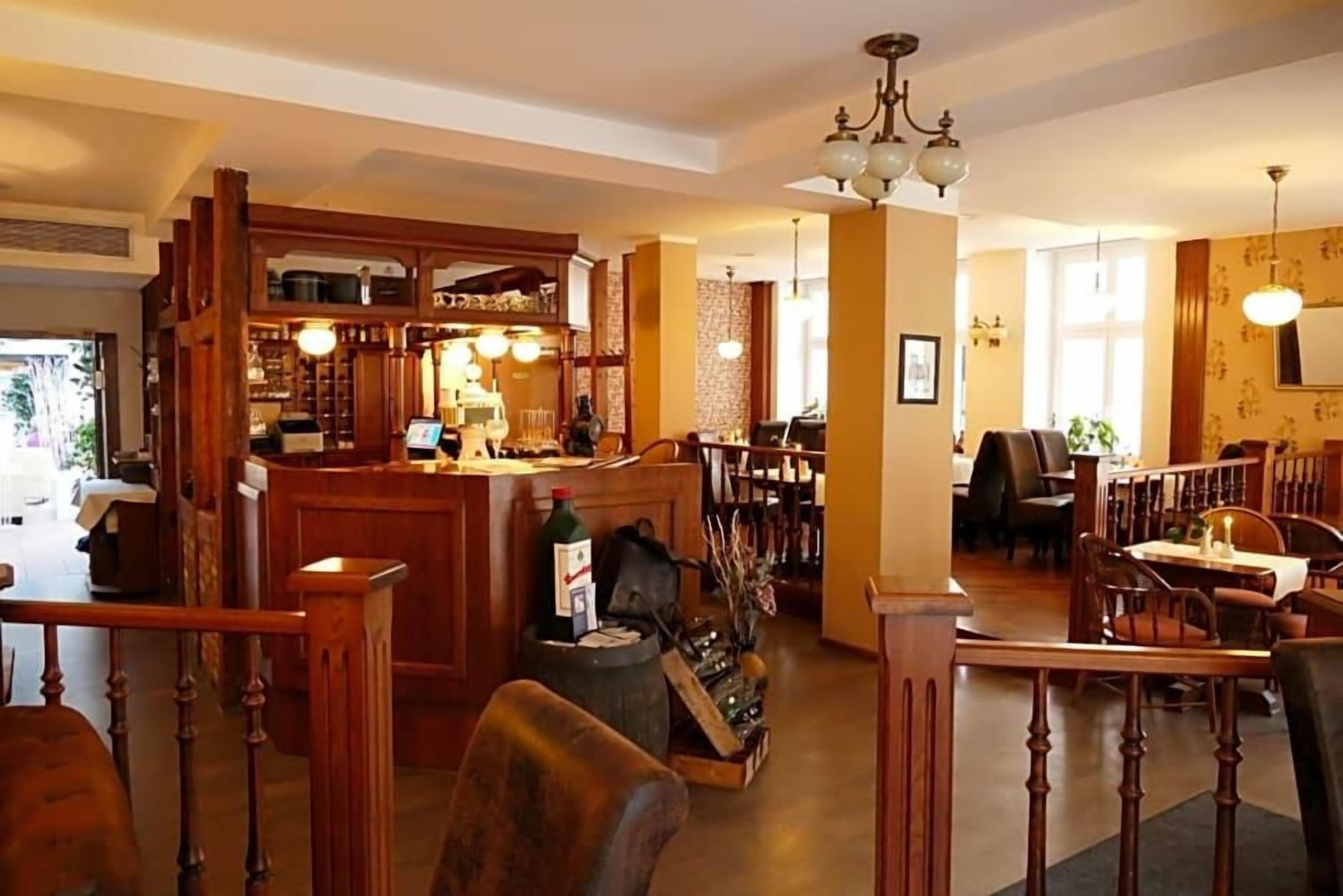 Ein Restaurant mit Holztischen, einer Bar und einer Treppe zu einer weiteren Ebene.