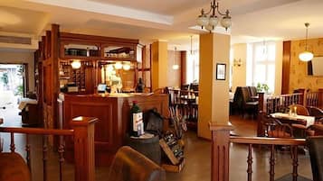 Ein Restaurant mit Holztischen, einer Bar und einer Treppe zu einer weiteren Ebene.
