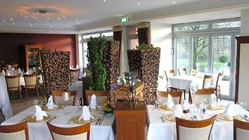 Een restaurant met gedekte tafels, een decoratief middelpunt en uitzicht op het buiten.