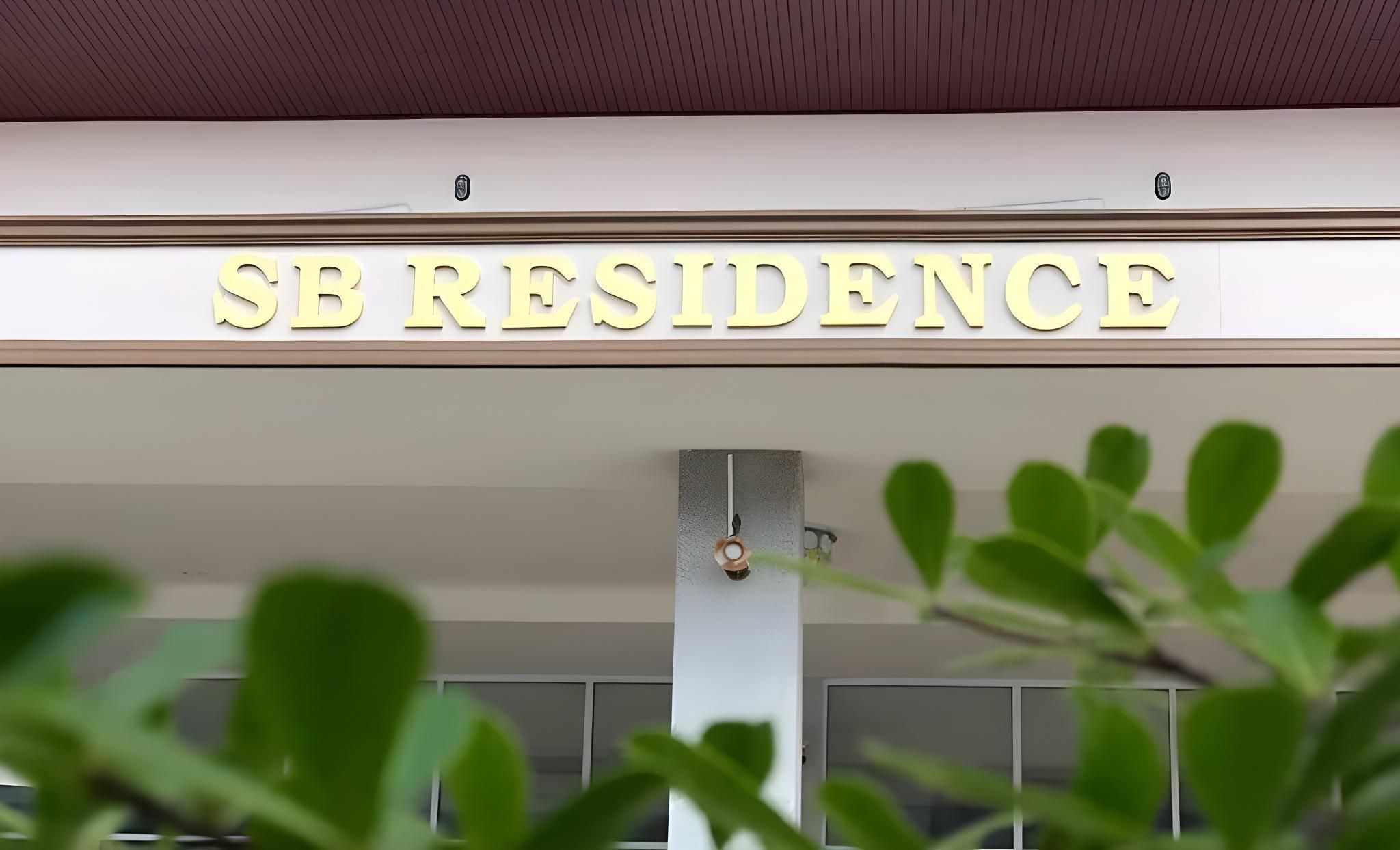 A sign for 'SB RESIDENCE' with a modern design and a clear view of the entrance.