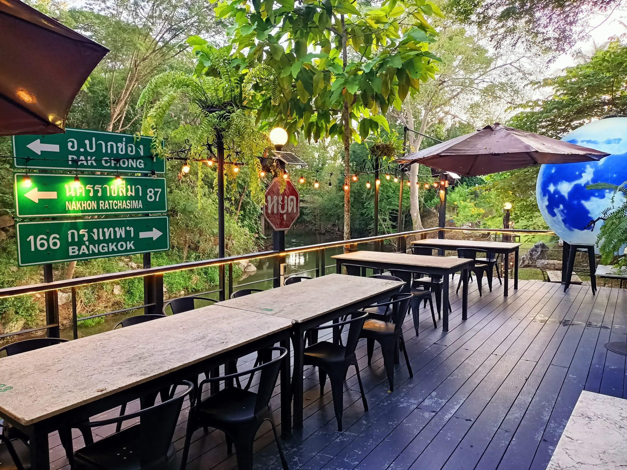 An outdoor dining area with tables and chairs, directional signs, and a decorative globe.