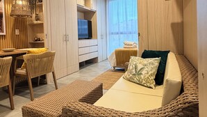 Een moderne woonkamer met een bank, een eethoek en een televisie.