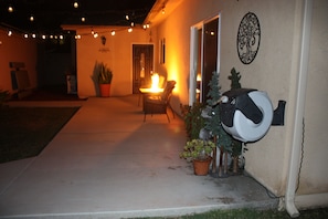An outdoor patio area with a fire feature, potted plants, and a decorative wall piece. - Lakeside Escape: King Bed, 2 Lakes, 2 Reservoirs, & 30 min.to Beach / San Diego (Lakeside)