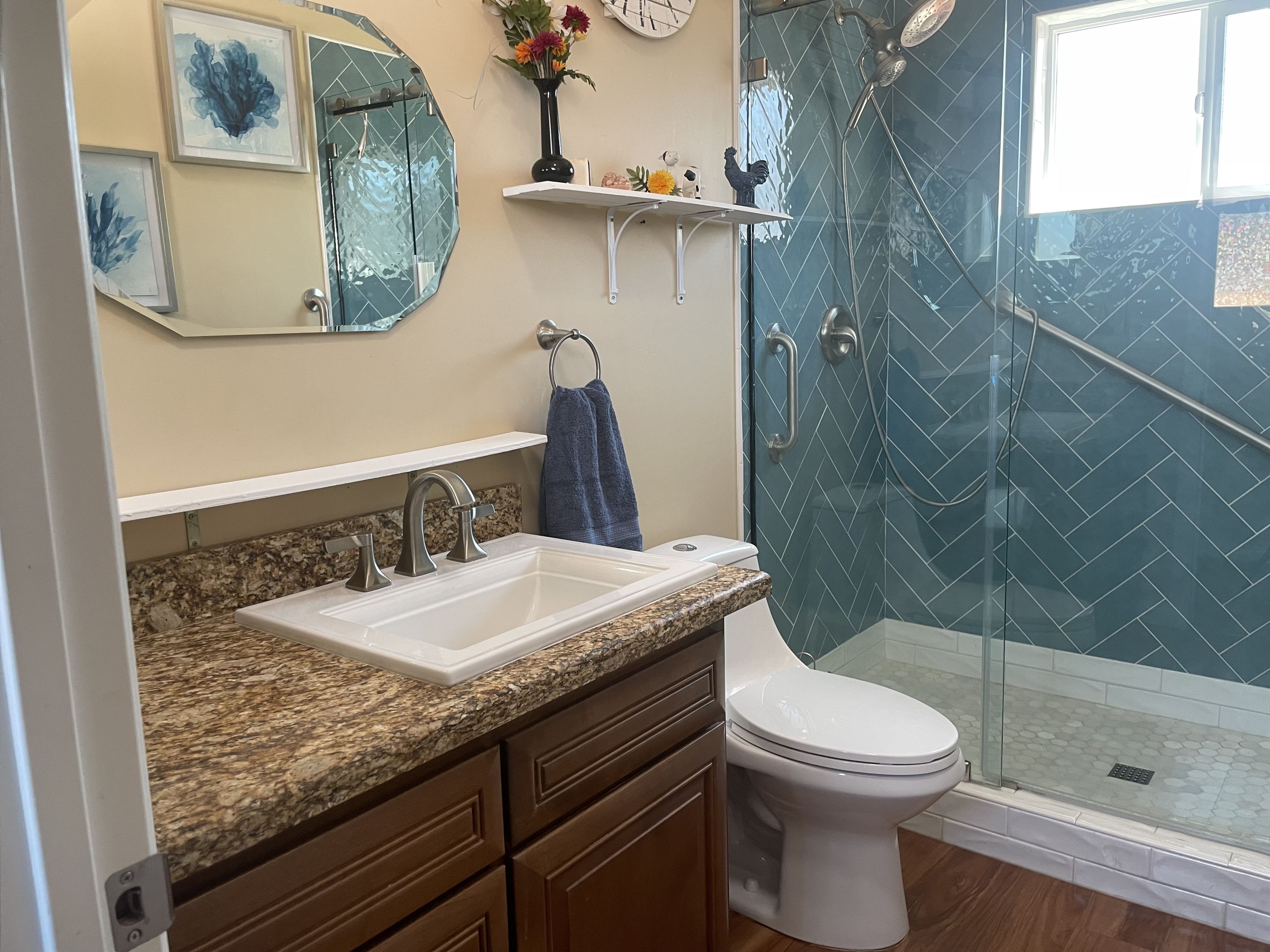 A bathroom with a glass-enclosed shower, a white sink, and a toilet.