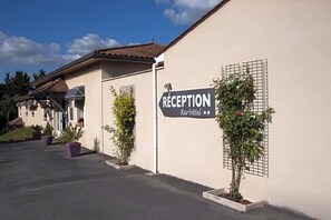 Zona de recepción de un hotel, con un cartel que indica 'RECEPTION Rev-Hotel'.