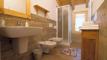 Un bagno con lavandino, bidet, WC e doccia.