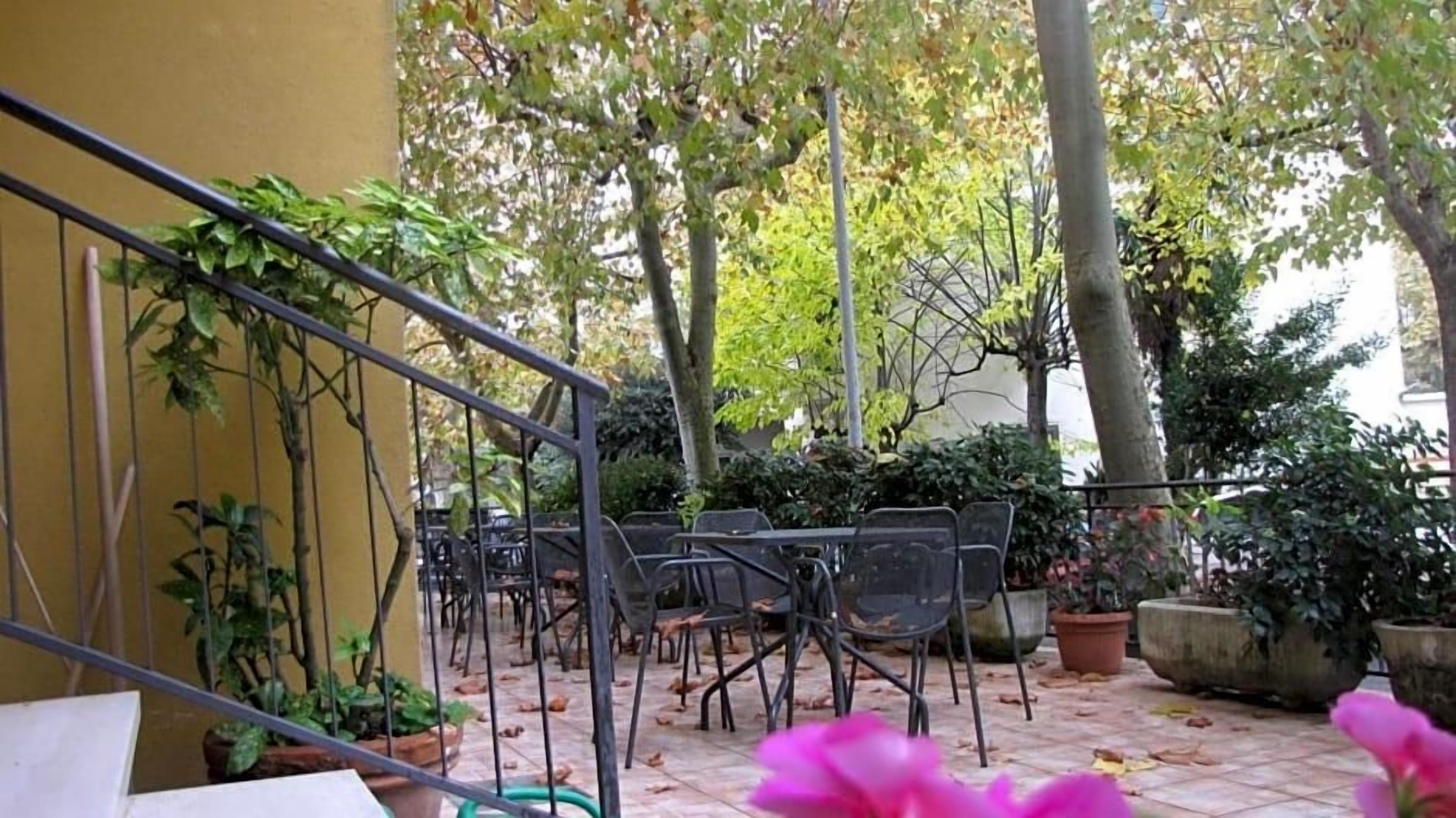 A courtyard with outdoor seating, potted plants, and a staircase.