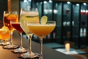 Un bar con varios vasos de cócteles.