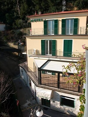 A two-story building with a restaurant on the ground floor and a hotel on the upper floor. - Hotel Adriana (Laigueglia)