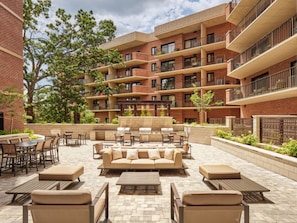 A courtyard with outdoor seating, including sofas and tables, surrounded by brick buildings with multiple balconies. - Blueground | Clarendon, gym, nr Arlington Cemetery (Arlington)